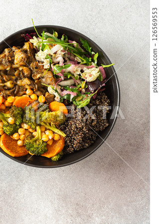 A wholesome breakfast of black quinoa, avocado, baked chicken, roasted vegetables like sweet potato, zucchini, and broccoli, along with a fresh salad of cabbage, radish, and chia seeds 126569553