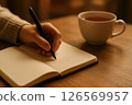 Writing by hand in notebook 126569957