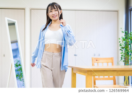 A young woman in casual clothes takes off her clothes, gets changed and heads to the gym Yoga Stretching Diet Health 126569964