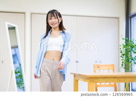 A young woman in casual clothes takes off her clothes, gets changed and heads to the gym Yoga Stretching Diet Health 126569965