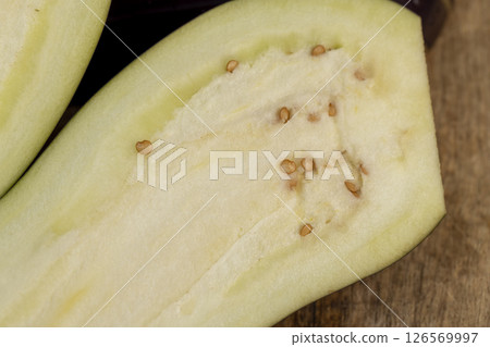 ripe eggplant sliced with seeds inside, ripe purple delicious eggplant sliced on the kitchen table, top view ripe eggplant sliced with seeds inside, ripe purple delicious eggplant sliced on the kitchen table, top view 126569997