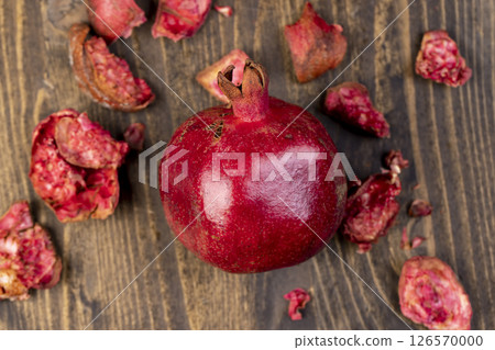 red ripe pomegranate on a table, sweet red pomegranate in the kitchen red ripe pomegranate on a table, sweet red pomegranate in the kitchen 126570000