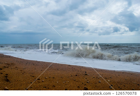 stormy coastal sea against the background of a cloudy sky covered with solid clouds 126570078
