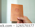 A man's hand holds a marriage certificate of the USSR model 126570377