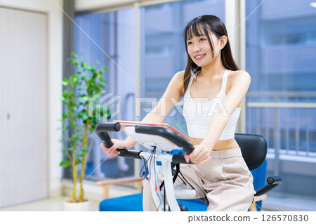 女人在家裡的房間裡騎健身自行車鍛煉,家裡,健身自行車,鍛煉 女人在家裡的房間裡騎健身自行車鍛煉,家裡,健身自行車,鍛煉 126570830