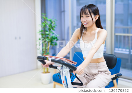 女人在家裡的房間裡騎健身自行車鍛煉，家裡，健身自行車，鍛煉 126570832