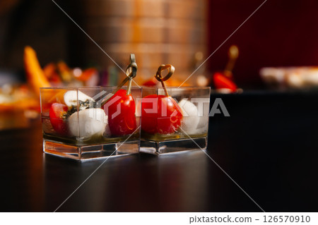 Two servings of La Caprese - a combination of fresh tomatoes, delicate mozzarella, fragrant dried basil and olive oil. 126570910