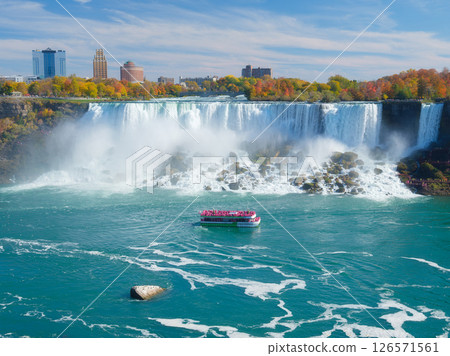 Niagara Falls. A pleasure boat with people near the huge famous waterfall.  126571561