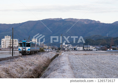 [Mugi Line] Limited express train passing through a frosty rural area 126571617