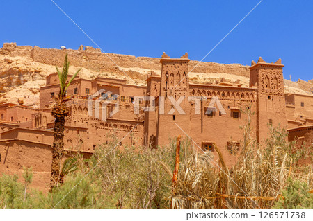 Ait Benhaddou ksar village walls and castle kasbah towers, with oasis in the foreground, Ouarzazate province, Morocco Ait Benhaddou ksar village walls and castle kasbah towers, with oasis in the foreground, Ouarzazate province, Morocco 126571738
