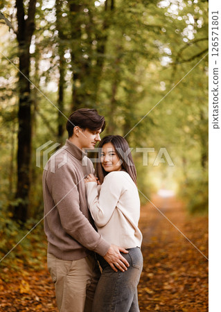 Happy couple embracing in autumn forest 126571801