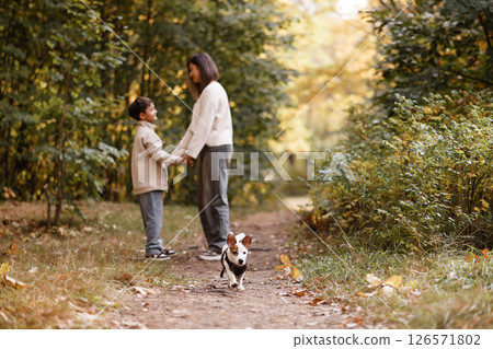 Mother and Son Holding Hands with Dog in Autumn Forest Mother and Son Holding Hands with Dog in Autumn Forest 126571802