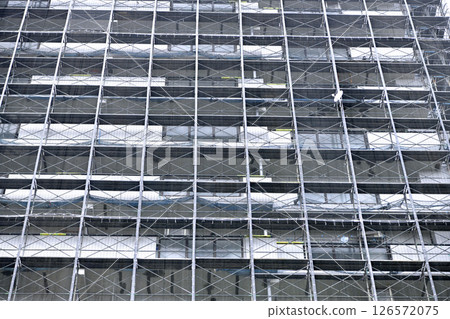 Yokohama cityscape in Japan. Apartment building repairs and inspections, scaffolding and protective nets. Satellite antennas outside the nets... Yokohama cityscape in Japan. Apartment building repairs and inspections, scaffolding and protective nets. Satellite antennas outside the nets... 126572075
