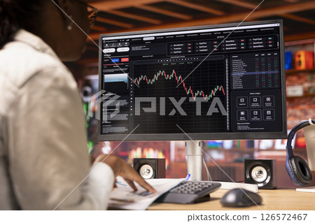 Day trader in home office purchasing stocks performing well, selling to gain money using PC display. Close up of woman browsing though stock exchange portfolio shares on computer screen Day trader in home office purchasing stocks performing well, selling to gain money using PC display. Close up of woman browsing though stock exchange portfolio shares on computer screen 126572467