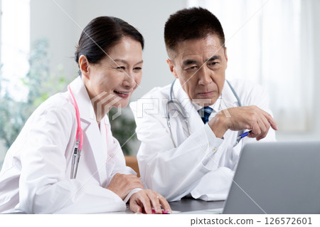 Two doctors checking the test results Two doctors checking the test results 126572601