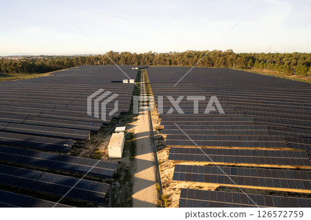 Wide solar farm with rows of solar panels across Wide solar farm with rows of solar panels across 126572759