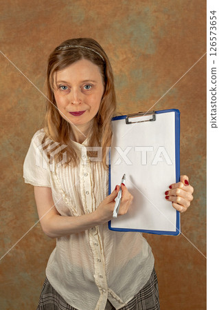 Holding blank paper with pencil on clipboard Holding blank paper with pencil on clipboard 126573654