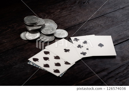 Dead man's hand and silver coins bet. Two-pair poker hand consisting of the black aces and black eights, held by Old West gunfighter Wild Bill Hickok when he was murdered while playing a game. 126574036