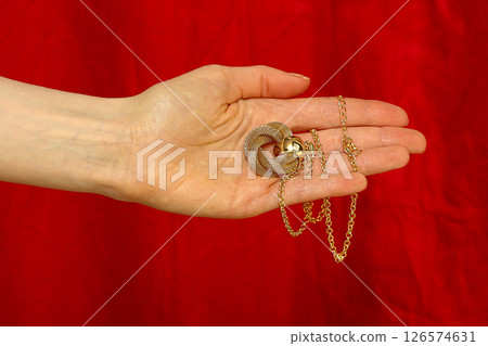 Female hand holding gold necklace 126574631