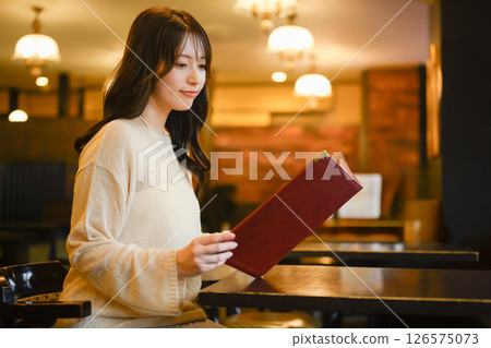 一位女顧客正在瀏覽菜單 126575073