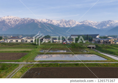 長野縣白馬村，白雪皚皚的白馬三山倒映在稻田中（無人機空拍） 126575167