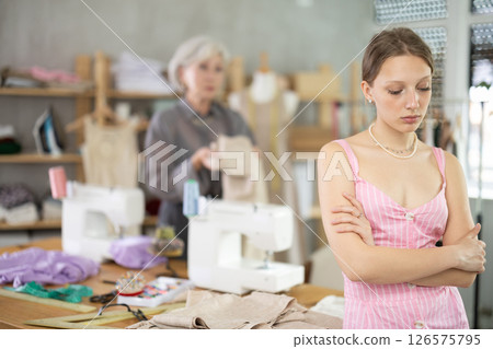 Mature dressmaker scolds assistant at work Mature dressmaker scolds assistant at work 126575795
