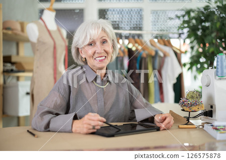 Woman dressmaker makes pattern using tablet 126575878