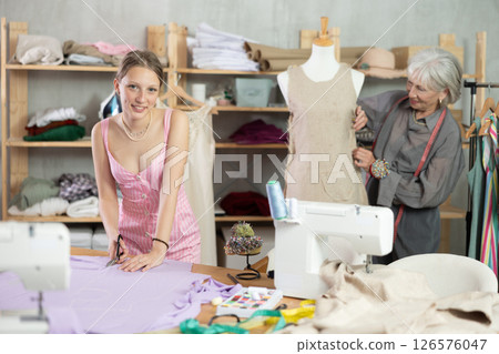 Young female dressmaker cutting textile other work with mannequin Young female dressmaker cutting textile other work with mannequin 126576047