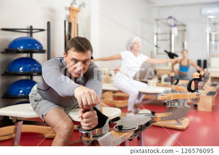 Man during Pilates training performs exercises and tasks on heron pulley tower 126576095