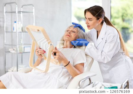 Mature patient with mirror, doctor with gloves 126576169