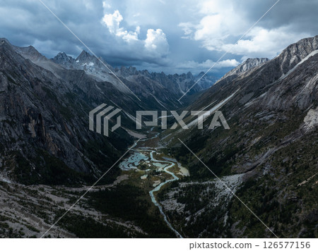 Aerial view of beautiful high altitude forest canyon and snow capped mountain landscape 126577156