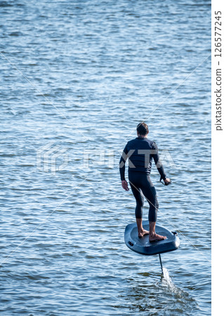 Hydrofoiling on a calm blue sea Hydrofoiling on a calm blue sea 126577245