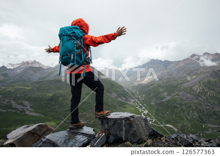 Happy hiking woman open arms to the beautiful landscape on high altitude mountain top Happy hiking woman open arms to the beautiful landscape on high altitude mountain top 126577363