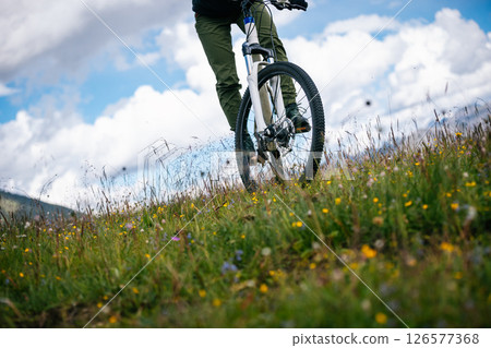 Riding mountain bike in the flowering beautiful mountain top Riding mountain bike in the flowering beautiful mountain top 126577368