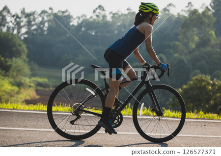 Woman cycling on summer park trail 126577371