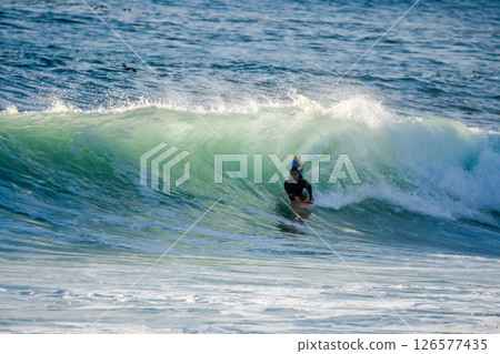 Bodyboarder surfing ocean wave 126577435