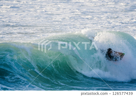 Bodyboarder surfing ocean wave Bodyboarder surfing ocean wave 126577439