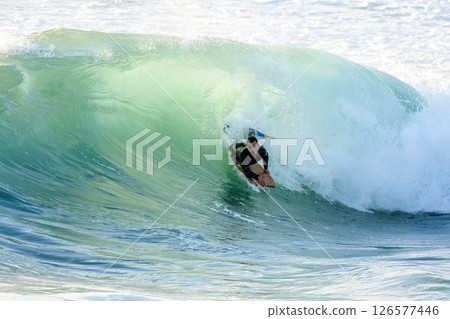 Bodyboarder surfing ocean wave 126577446