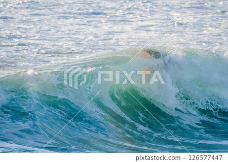 Bodyboarder surfing ocean wave 126577447