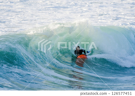 Bodyboarder surfing ocean wave 126577451