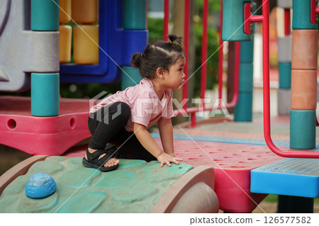 happy toddler girl playing at a outdoor playground in park 126577582