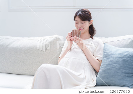 Pregnant woman drinking from a mug 126577630
