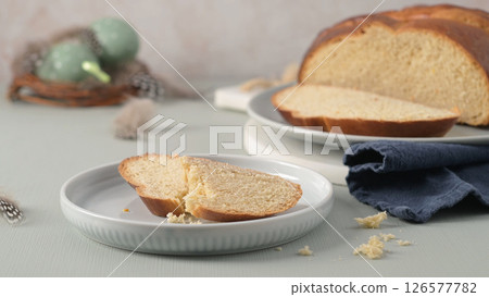 Traditional Portuguese folar slices on white plates amidst Easter decorations Traditional Portuguese folar slices on white plates amidst Easter decorations 126577782