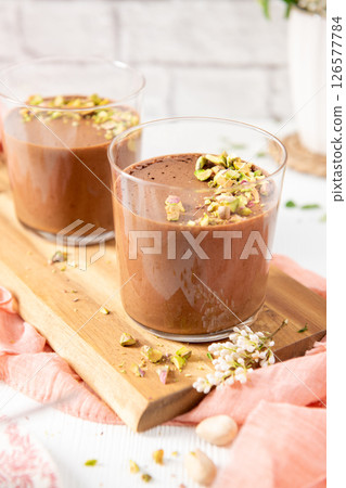 Two chocolate mousses with pistachios on a board Two chocolate mousses with pistachios on a board 126577784