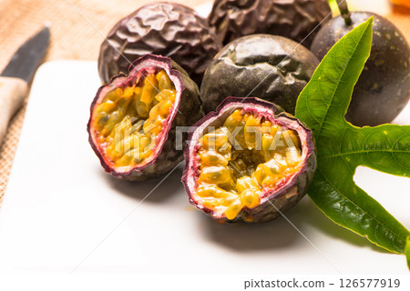 Passion fruits on white ceramic tray on wooden table background. Passion fruits on white ceramic tray on wooden table background. 126577919