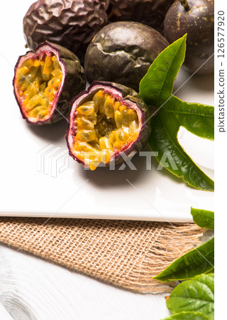 Passion fruits on white ceramic tray on wooden table background. 126577920