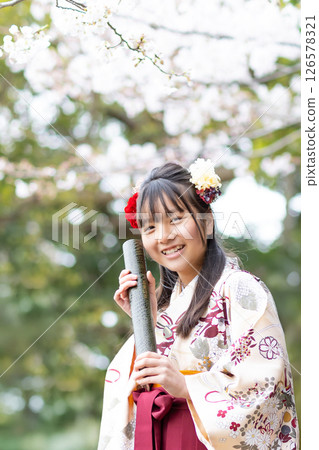 A girl in a hakama holding a certificate at an elementary school graduation ceremony A girl in a hakama holding a certificate at an elementary school graduation ceremony 126578321