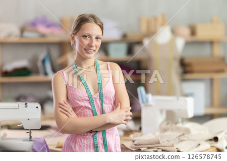 Young woman seamstress invites to the workshop Young woman seamstress invites to the workshop 126578745