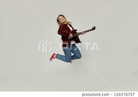 Attractive young girl playing the guitar on a white background 126578787
