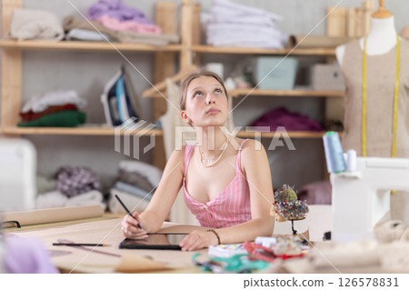 Woman dressmaker makes pattern using tablet 126578831